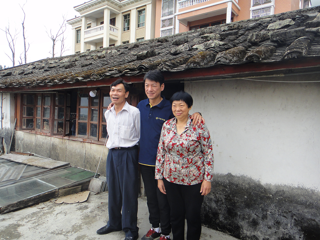 Vater, jüngster Sohn und Mutter der Familie Lan auf dem Balkon des alten Hauses in Shiguping
