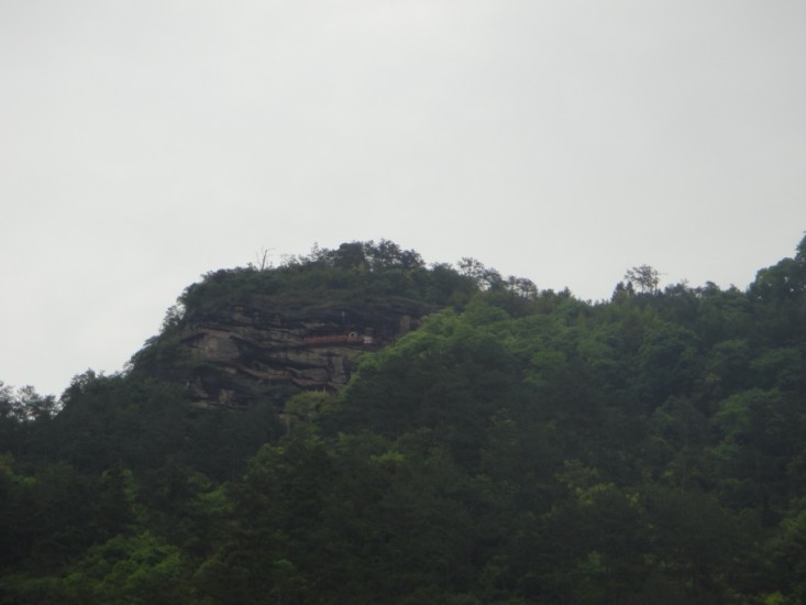 Hoch oben am Berg im Fels sieht man rot den Tempel